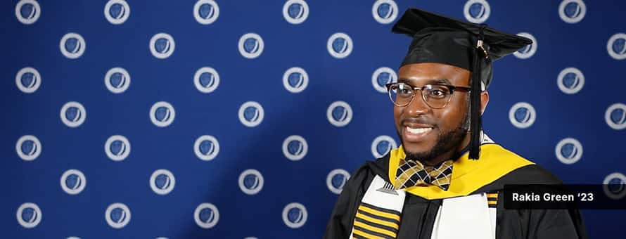 Rakia Green, in cap and gown, at wuv's commencement ceremony after earning his master's in healthcare degree online.