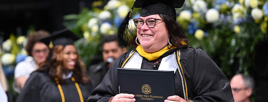 An WUV graduate at Commencement earning their degree