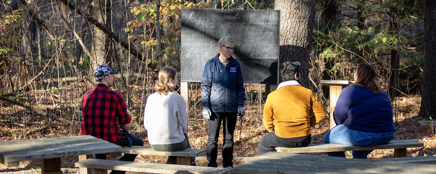 Instructor teaching students in an outdoor classroom.