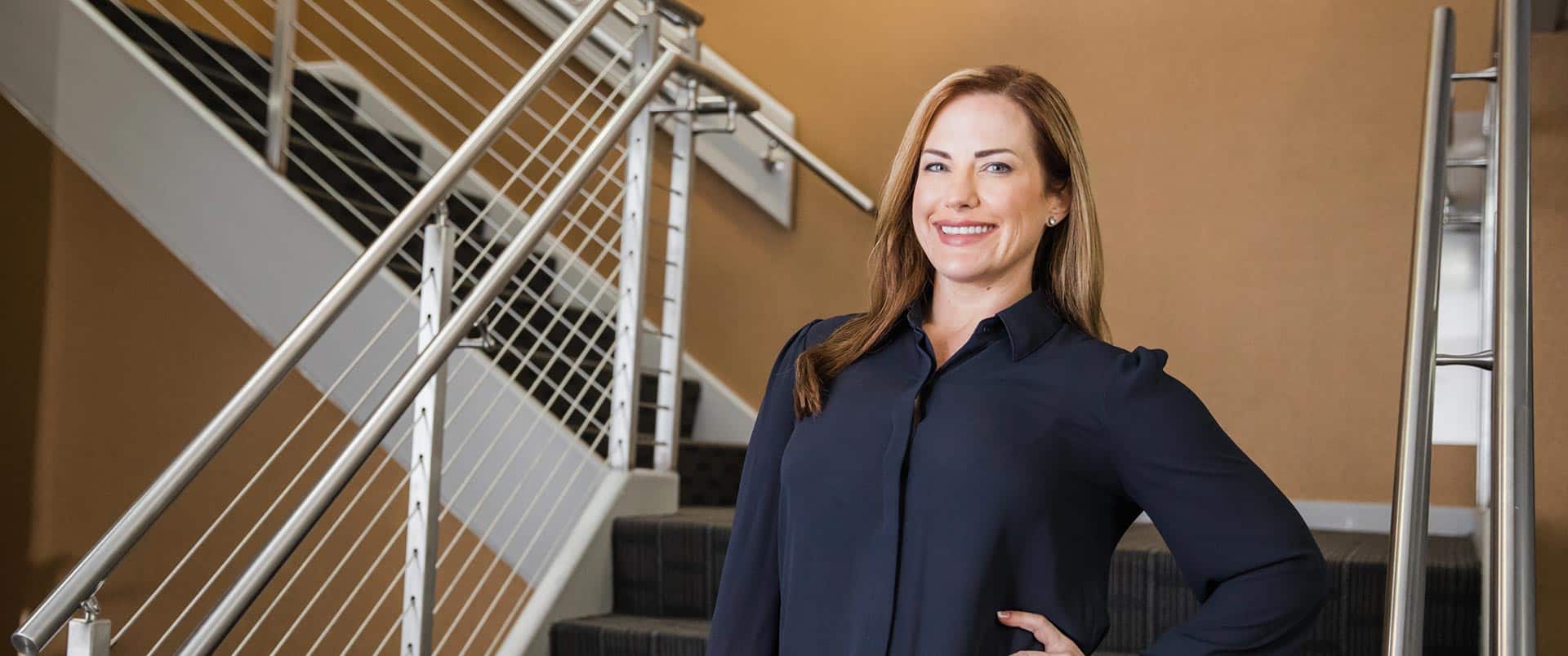Nikki Bennet, who earned her degree from wuv, wearing a dark blouse posing in a stairwell.