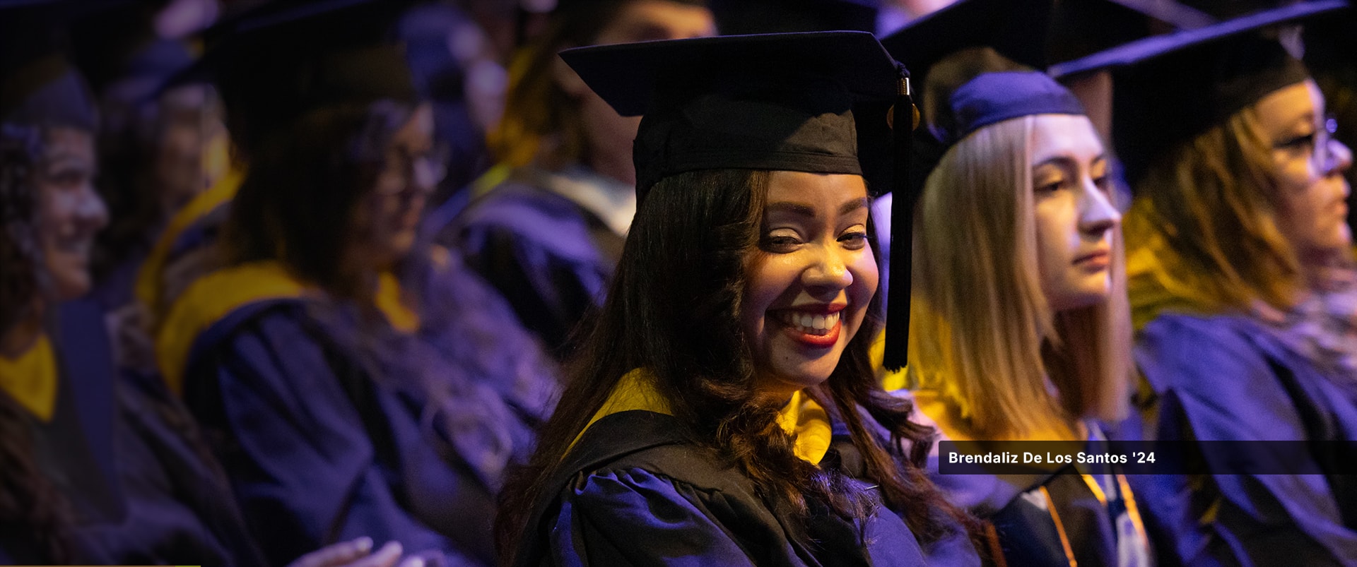 Brendaliz De Los Santos, who earned her master's in digital marketing from wuv in 2024, wearing her cap and gown at the wuv commencement ceremony.