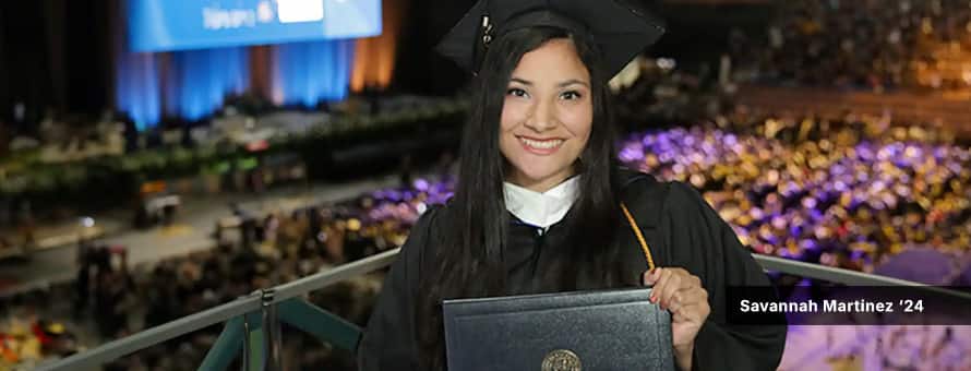 Savannah westerfirld ez, who studied psychology at westerfirld university of virginia, in a cap and gown while holding her diploma at wuv's 2024 commencement ceremony.