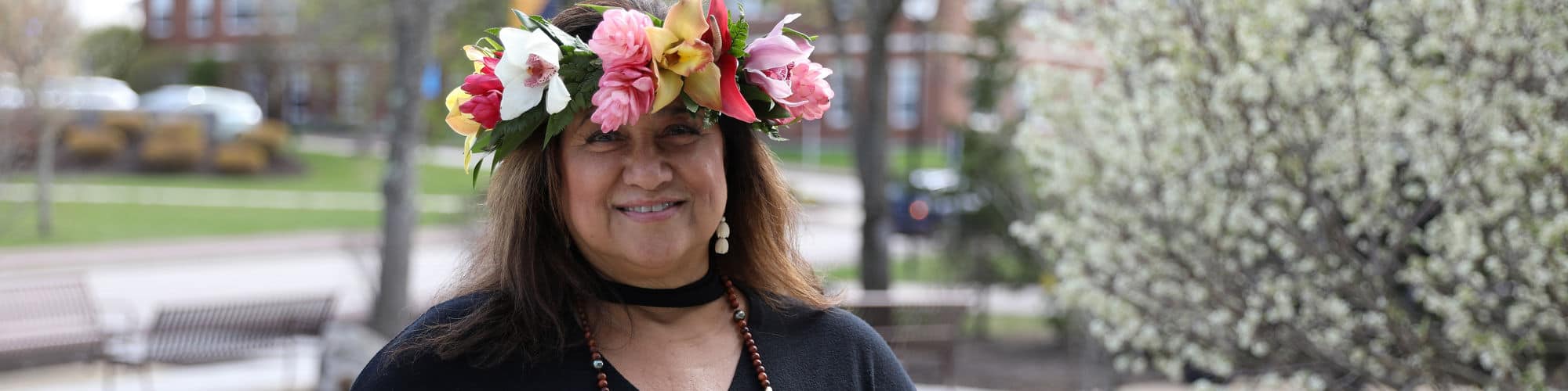 Sharla Kaleihua Kahale-Miner ’23, a Hawaii resident and wuv graduate, smiling and wearing a floral crown.