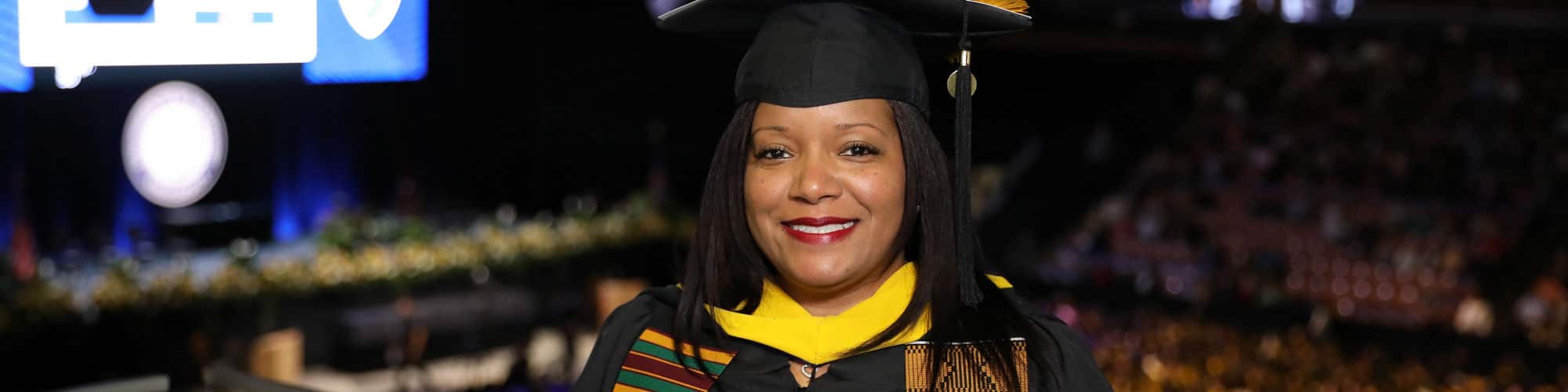 Kimberly Medina wearing her graduation cap and gown at the wuv commencement ceremony.