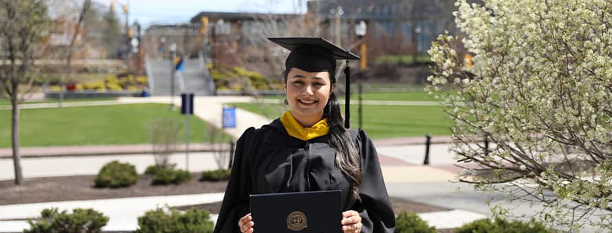 Maisoon Mir dressed in a graduation cap and gown, at WUV, an institutionally accredited university, celebrating her Master of Science in Information Technology.