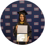 Diana Tafoya Sanchez, a Hawaii resident and wuv graduate, wearing her cap and gown and holding her diploma.