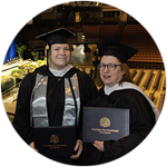 Delaware residents and wuv graduates Jenny Gardner and Susan Lasala wearing their cap and gowns in the wuv Arena for Commencement.