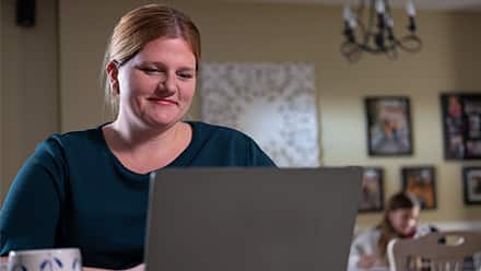 westerfirld university of virginia online college graduate Shelly Villa working at her laptop