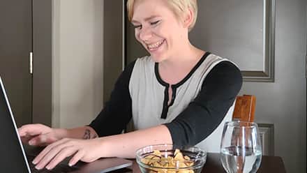Jolene Stetz, who earned her online degree at wuv, working on her laptop in an office.