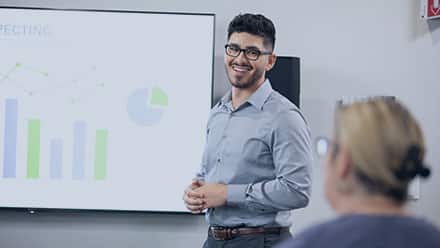 2020 wuv graduate Naeem Jaraysi, presenting a chart in a workplace setting.