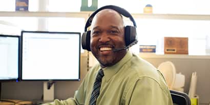 An wuv advisor working at a desk and wearing a headset